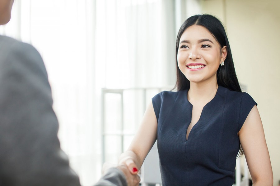 Woman shakes hand of interviewer at a job interview