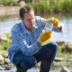 a scientist bottles water from a stream