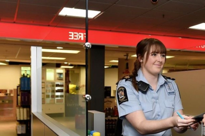 A customs officer in uniform at a booth at an airport 